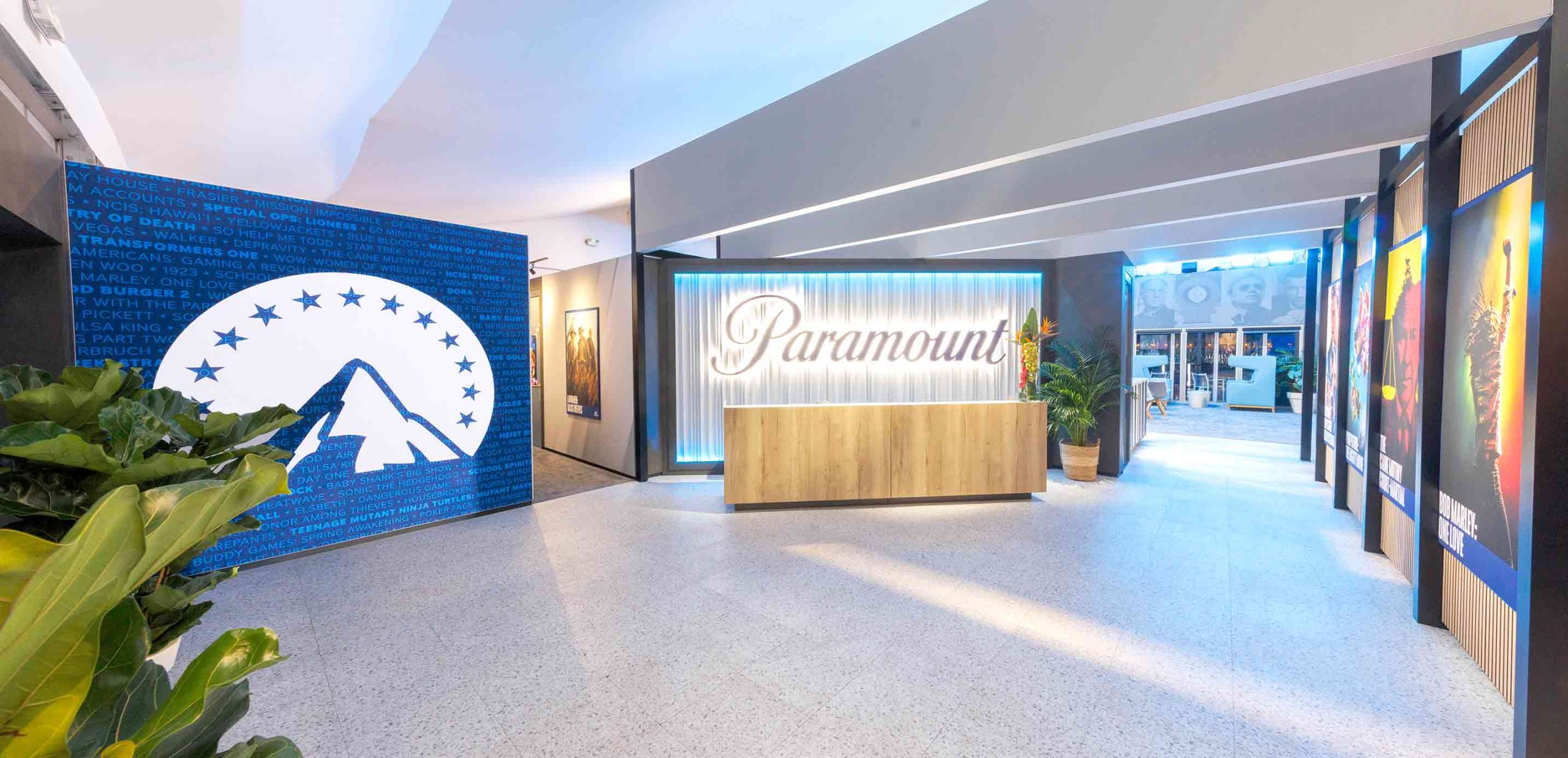 Paramount exhibition stand main entrance with illuminated logo, blue feature wall, and modern interior by Beautiful LFP.