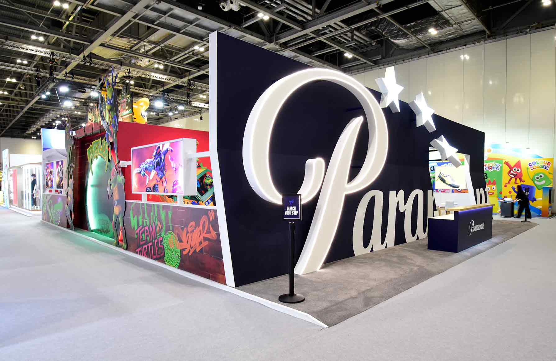 Paramount exhibition stand with illuminated 3D logo, star lighting, and branded display areas by Beautiful LFP.