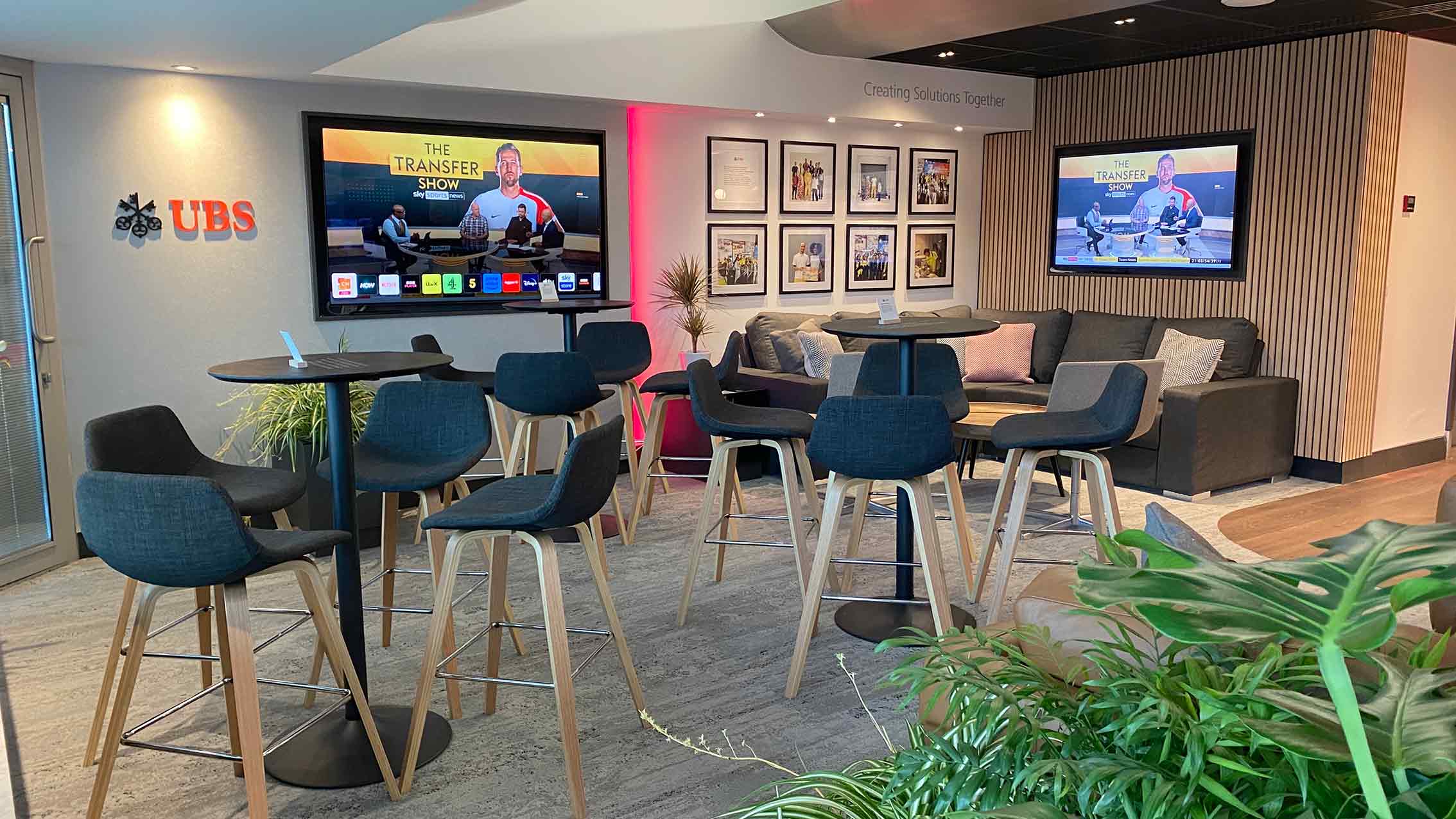 UBS VIP Lounge seating area at Chelsea FC’s Stamford Bridge, featuring high tables, digital screens, and bespoke printed branding by Beautiful LFP.